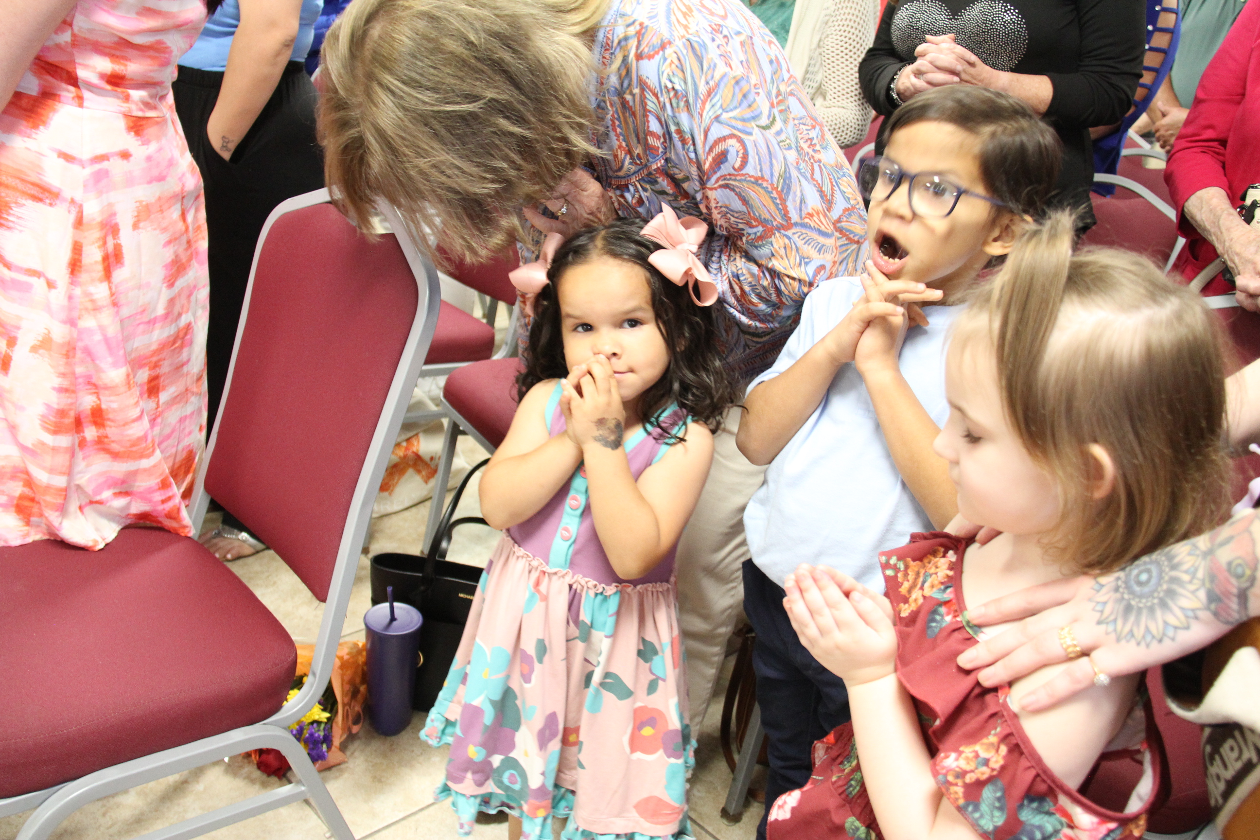 The children close their hands in prayer. An excited Ayden expresses his prayers with a big voice. Ayva and Ophelia fold their hands in quiet prayer for Stacy and all those who need uplifting,